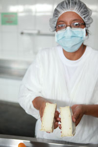 En la planta, Milagros muestra el queso / Foto: Archivos LEISA-AL En la planta, Milagros muestra el queso / Foto: Archivos LEISA-AL